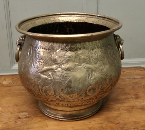fig 1. A 19th-century brass jardiniere featuring embossed heraldic lions, a shield motif with a motto, and lion head drop handles.