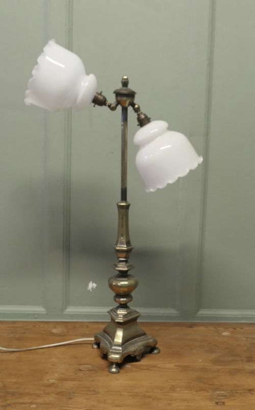 fig 1. An antique brass table lamp with a stepped pedestal base, central turned column, and two angled arms supporting white frilled glass shades.
