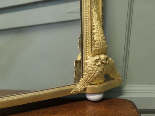 fig 1. An arched gold giltwood overmantel mirror with fern leaf cresting and small corner feet.