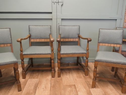 fig 2. A set of eight Arts and Crafts golden oak dining chairs with upholstered seats and backrests trimmed with brass studs.