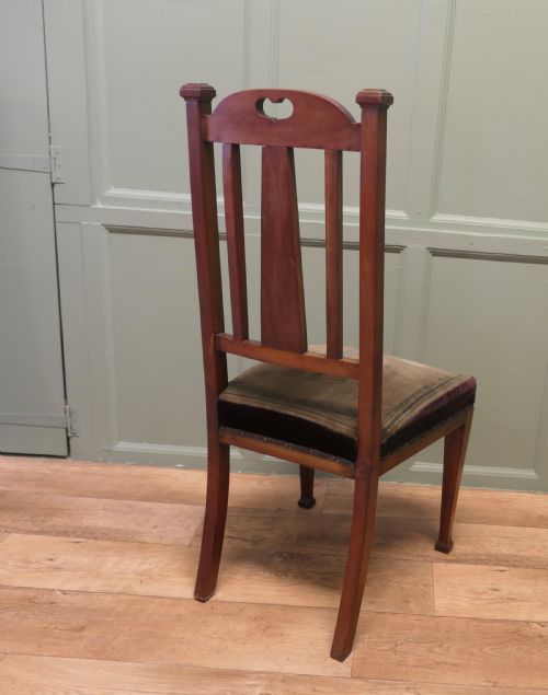 fig 2. A set of six golden oak Arts and Crafts dining chairs featuring vertical slatted backs with top rail cutouts and dark green upholstered seats.