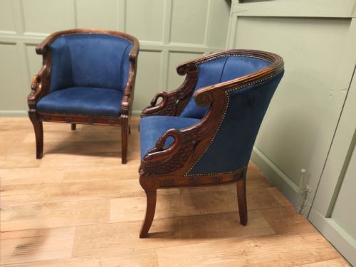 fig 1. A pair of Victorian tub chairs with blue upholstery and carved mahogany frames featuring carved swan neck armrests.