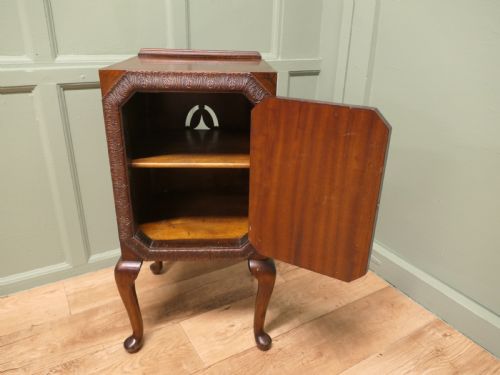 fig 1. An Art Deco burr walnut bedside cabinet featuring a carved door frame, brass latch, low gallery back, and four cabriole legs.