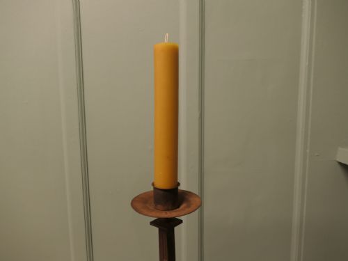 fig 1. A tall hand-forged wrought iron floor candlestick with a twisted central stem, collar joins, a drip tray sconce, and a splayed tripod base.