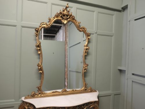 fig 1. A 19th-century Italian giltwood console table featuring an ornate carved frame, cabriole legs, a white marble top, and a matching gilt-framed wall mirror.