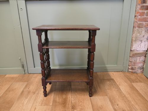 fig 1. A dark oak three-tier Arts and Crafts side table featuring turned legs and spindled side galleries.