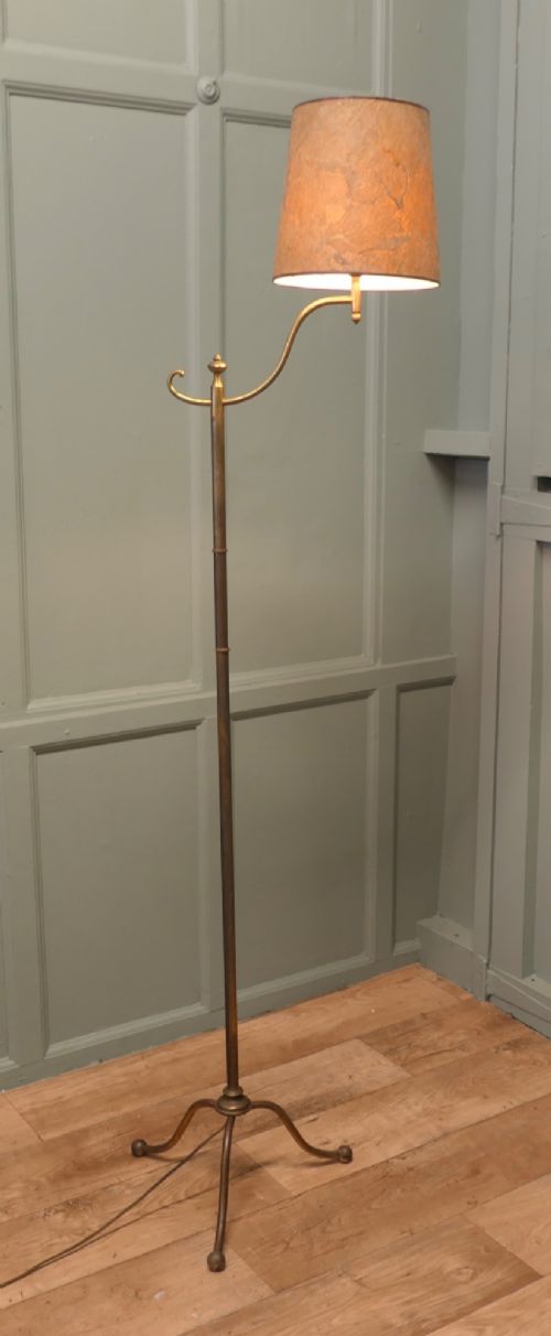 A French Arts and Crafts brass floor lamp featuring a slender stem, tripod base, curved adjustable arm, and a mottled parchment shade. View V