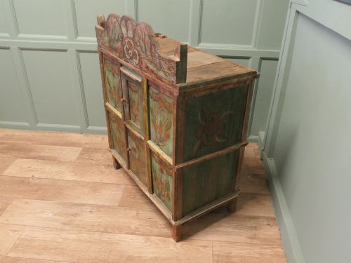 fig 1. A rustic French folk art painted pine cupboard with green and orange floral panels and a scalloped gallery top.