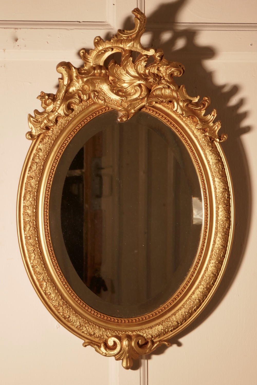 A Dainty French Rococo Oval Gilt Wall Mirror