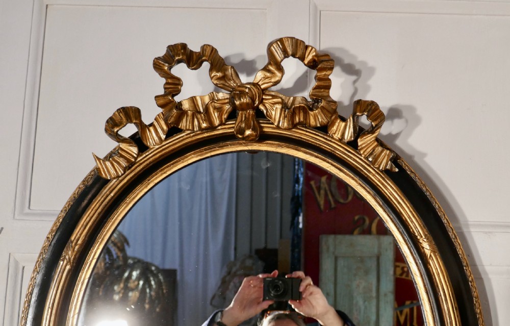 A Large French Ebonised and Gilt Oval Wall Mirror View III
