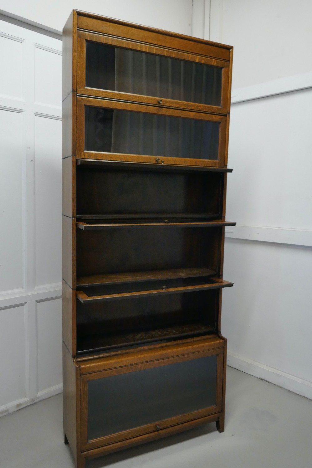 A Tall Art Deco Golden Oak Barrister Waterfall Bookcase, made by Gumm View V