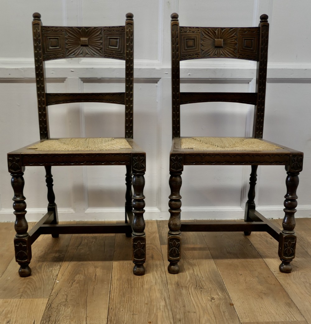 A Pair of Arts and Crafts Gothic Carved Oak Hall Chairs
