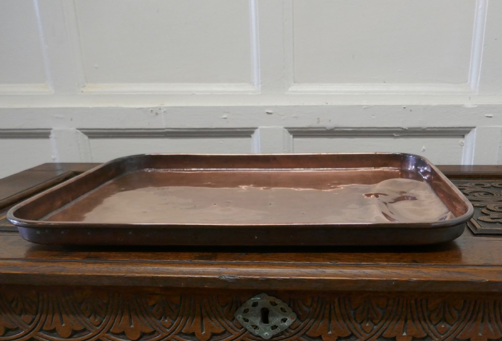 A large rectangular copper roasting tray featuring rolled rims and an indented oval gravy well at one end. View IV
