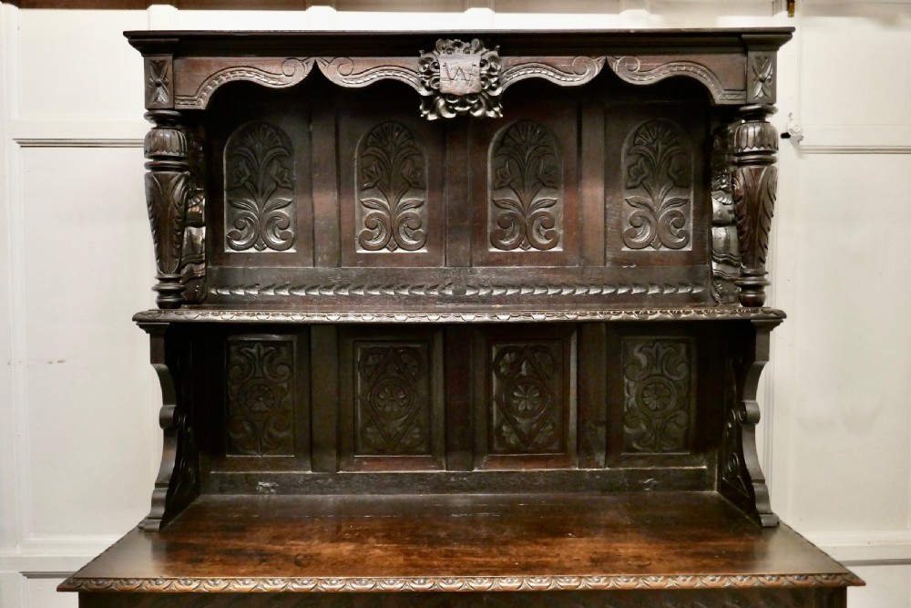 An 18th-century carved dark oak Welsh dresser featuring an upper open plate rack with carved panels above a lower cabinet base with drawers and doors. View VII