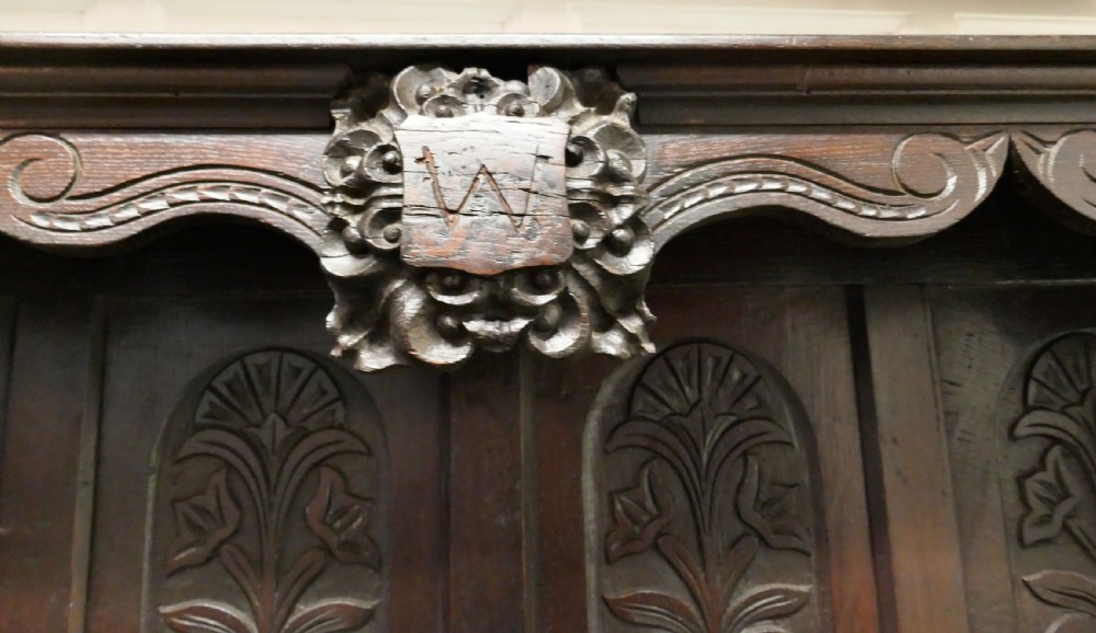 An 18th-century carved dark oak Welsh dresser featuring an upper open plate rack with carved panels above a lower cabinet base with drawers and doors. View XIV