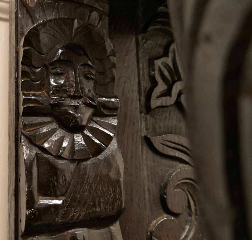 An 18th-century carved dark oak Welsh dresser featuring an upper open plate rack with carved panels above a lower cabinet base with drawers and doors. View XVI