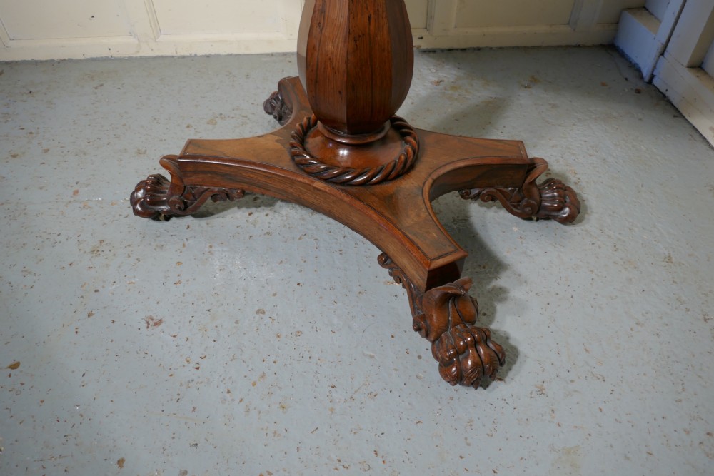 A William IV dark wood folding card table featuring a carved frieze, central turned pedestal, and a concave quadform plinth base with scroll feet. View II