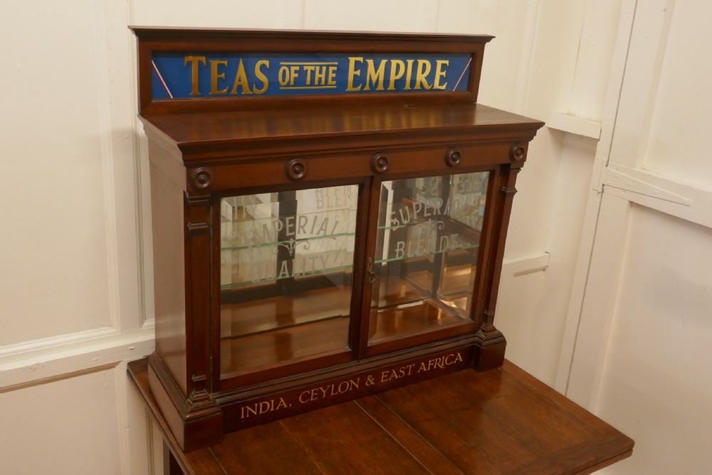 A Victorian mahogany shop counter display cabinet with etched glass doors, mirror backing, and gold lettering reading Teas of the Empire. View III