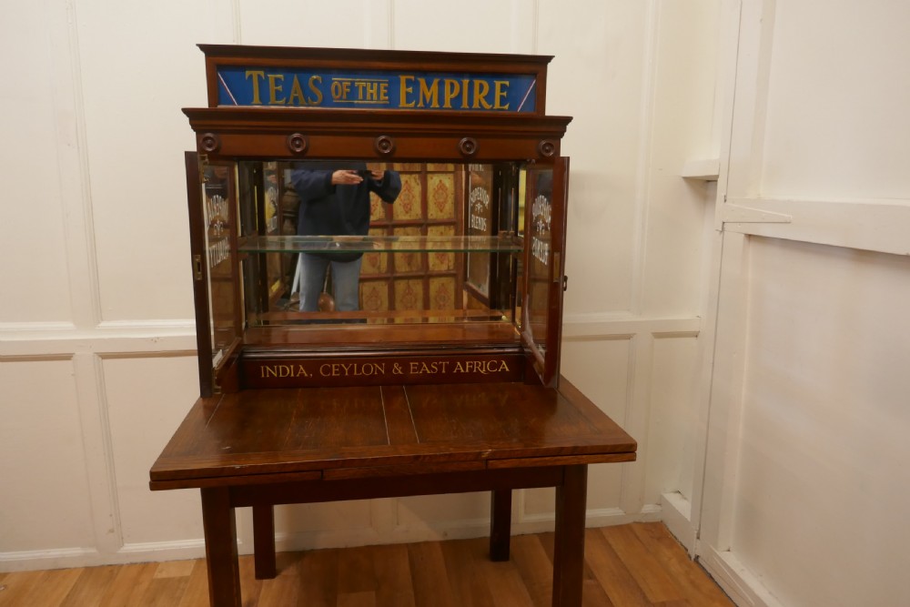 A Victorian mahogany shop counter display cabinet with etched glass doors, mirror backing, and gold lettering reading Teas of the Empire. View IX