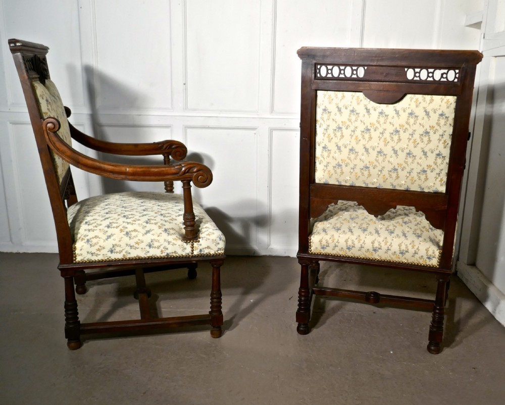 A pair of carved dark wood French Gothic armchair thrones with floral upholstered backrests and seats. View II