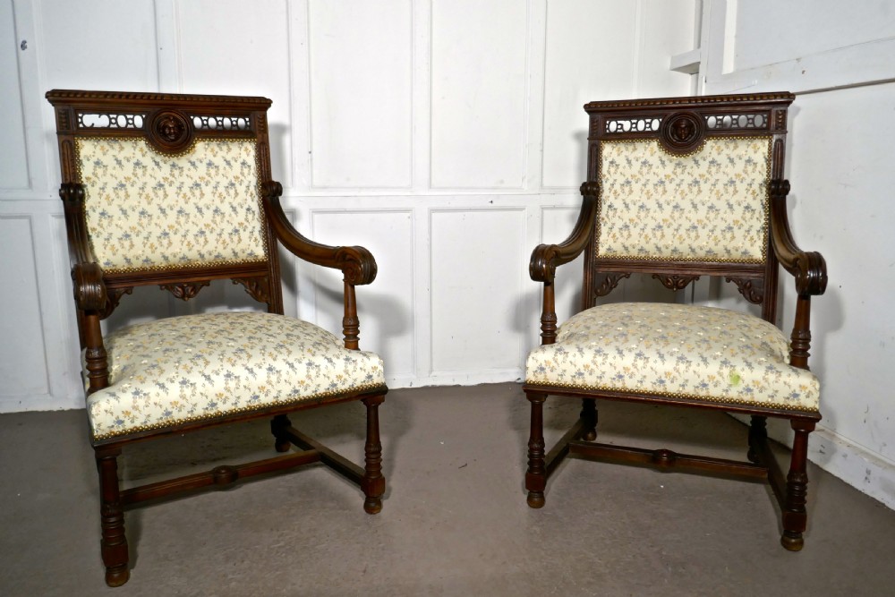 A pair of carved dark wood French Gothic armchair thrones with floral upholstered backrests and seats. View VI