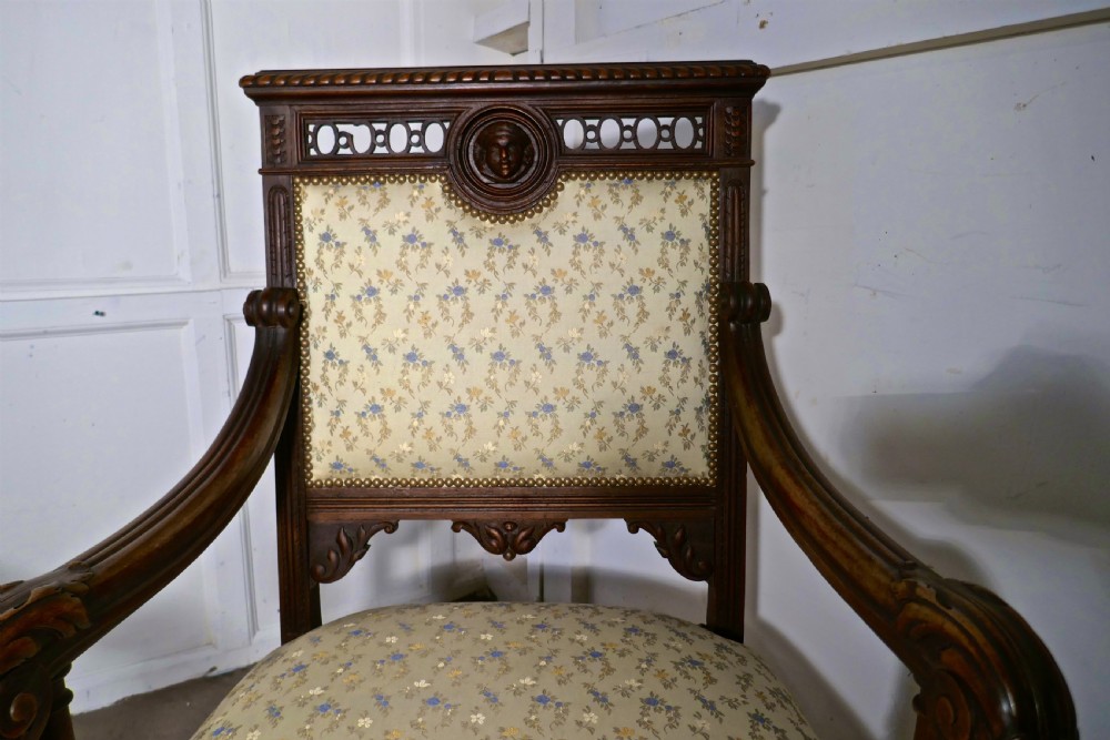 A pair of carved dark wood French Gothic armchair thrones with floral upholstered backrests and seats. View X