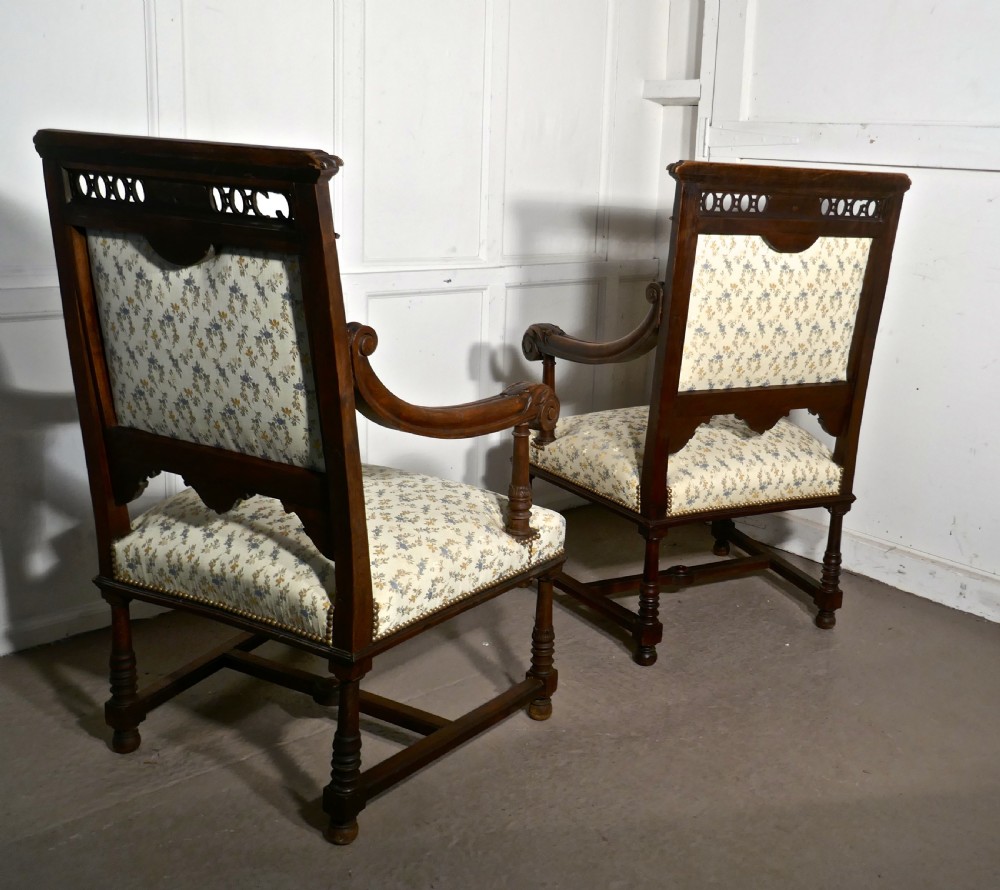 A pair of carved dark wood French Gothic armchair thrones with floral upholstered backrests and seats. View XII