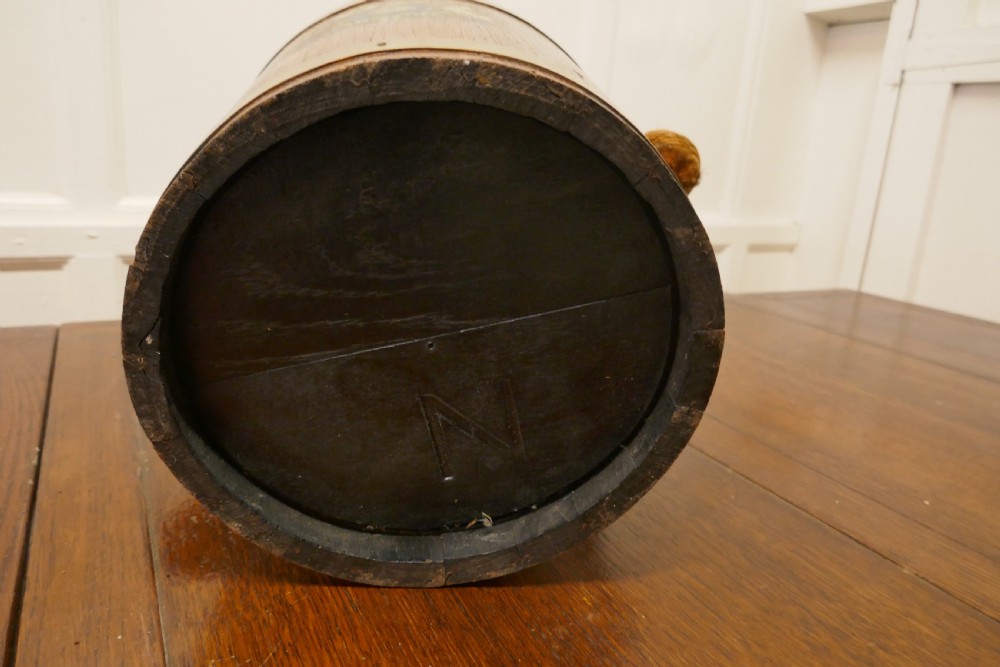 A 19th-century dark oak fire bucket featuring brass binding, a thick rope handle covered in brown leather, and a painted Plymouth armorial crest on the front. View III