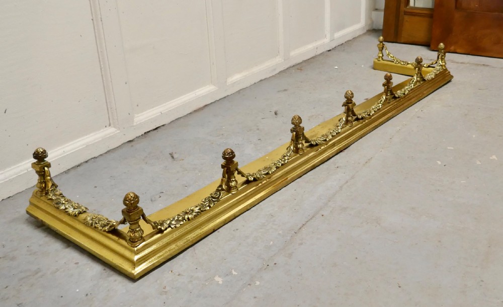 A 19th-century brass fireplace fender curb featuring baluster posts with pinecone finials and cast brass floral garlands. View III