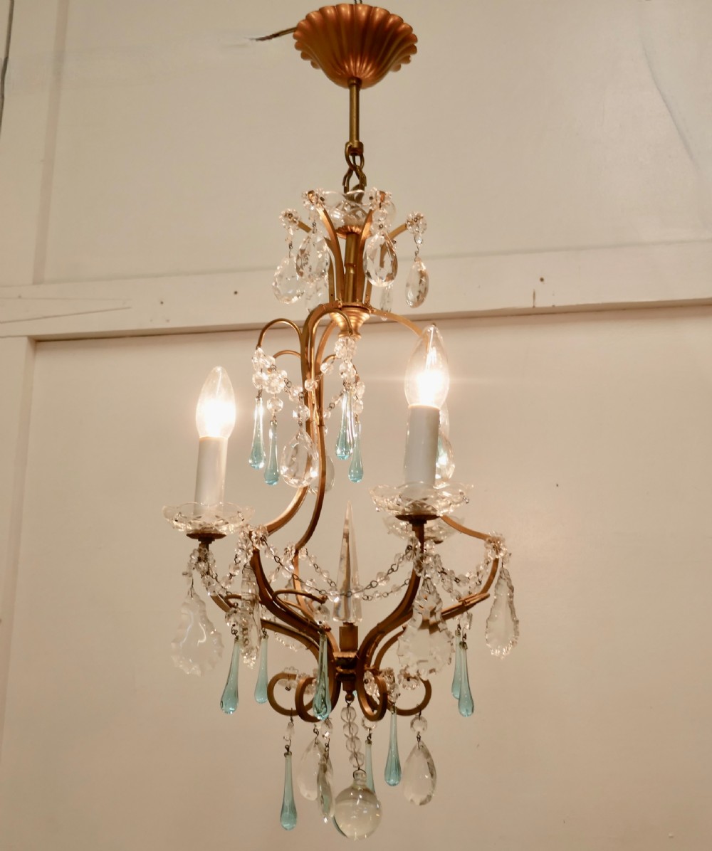 A French brass ceiling chandelier with curved metal arms, clear crystal prisms, beaded glass chains, and turquoise blue teardrop pendants. View VIII
