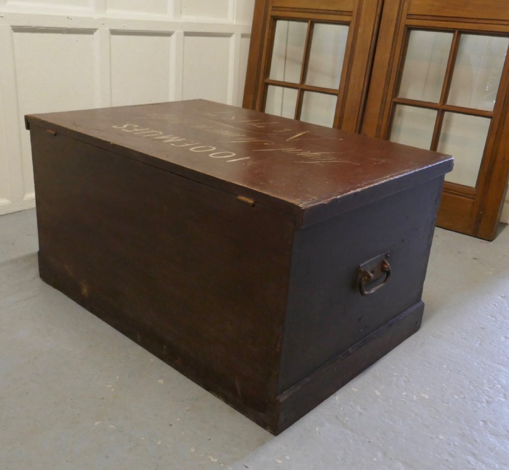 A 19th-century dark stained pine lodge chest featuring white painted lettering on the hinged top lid and a solid plinth base. View VII