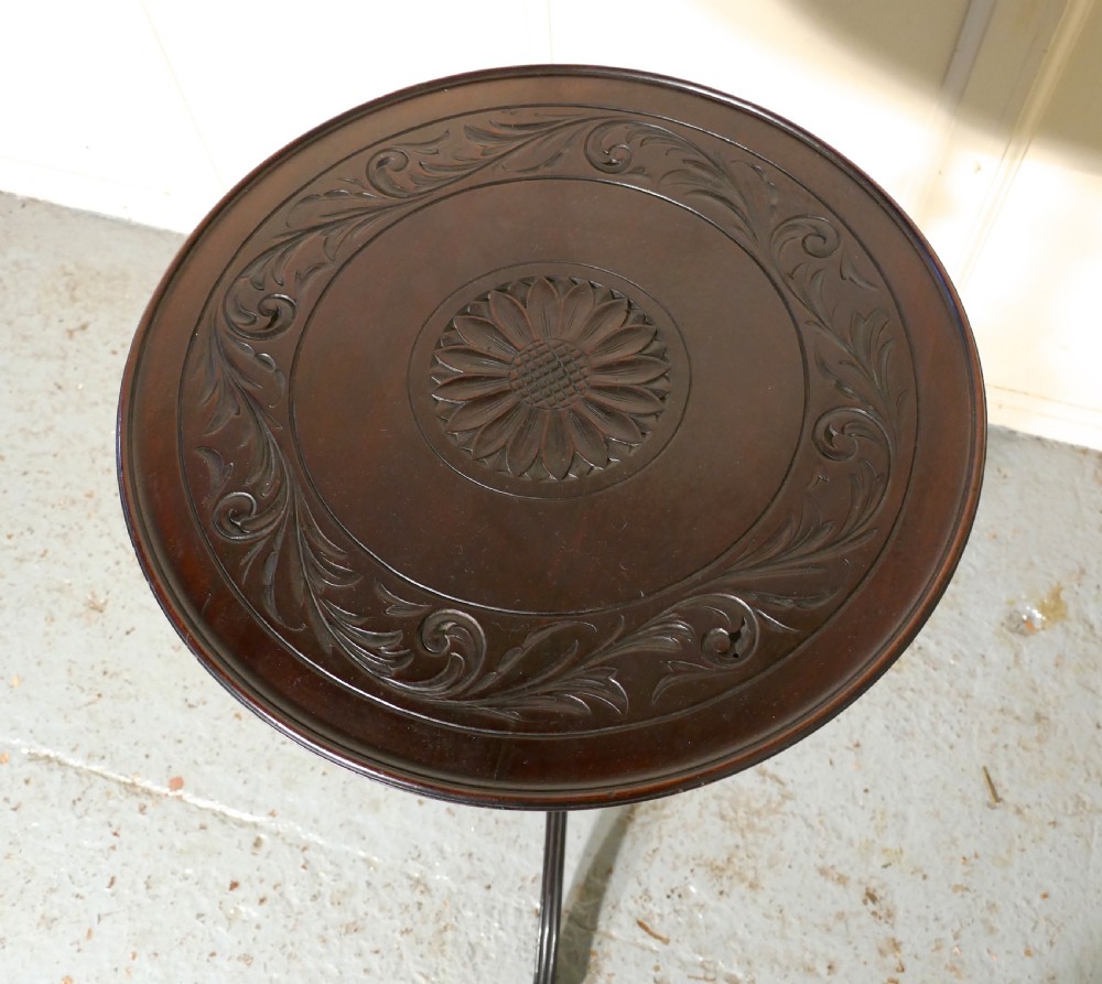 A dark mahogany Art Nouveau wine table featuring a circular two-tone carved top and sweeping tripod legs. View VI