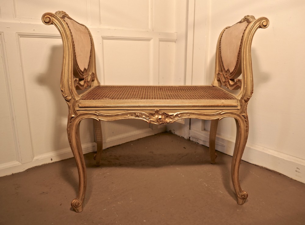 An antique French giltwood window seat featuring raised dusky pink velvet ends with studding, a cane seat, and curved cabriole legs. View III
