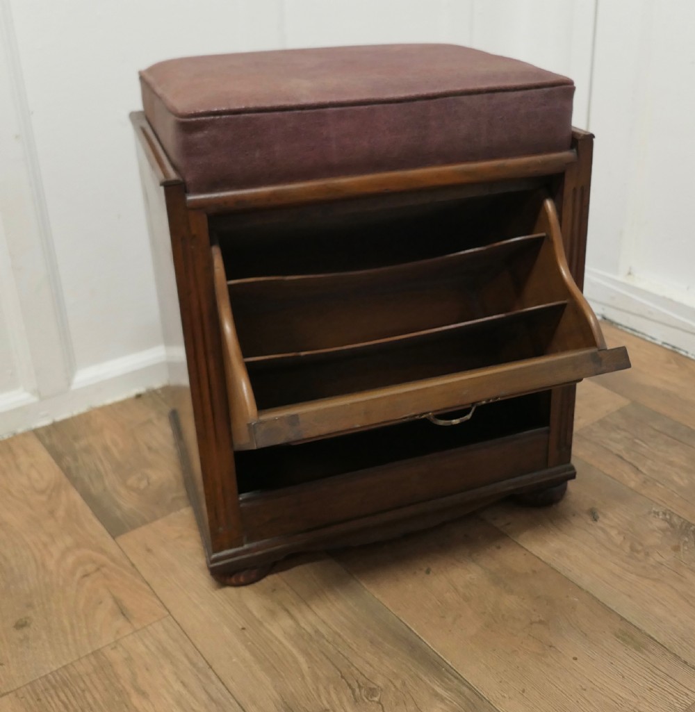 A dark walnut Victorian piano stool featuring a deep cushioned seat, moulded front fall panel, and a central brass drop handle. View V
