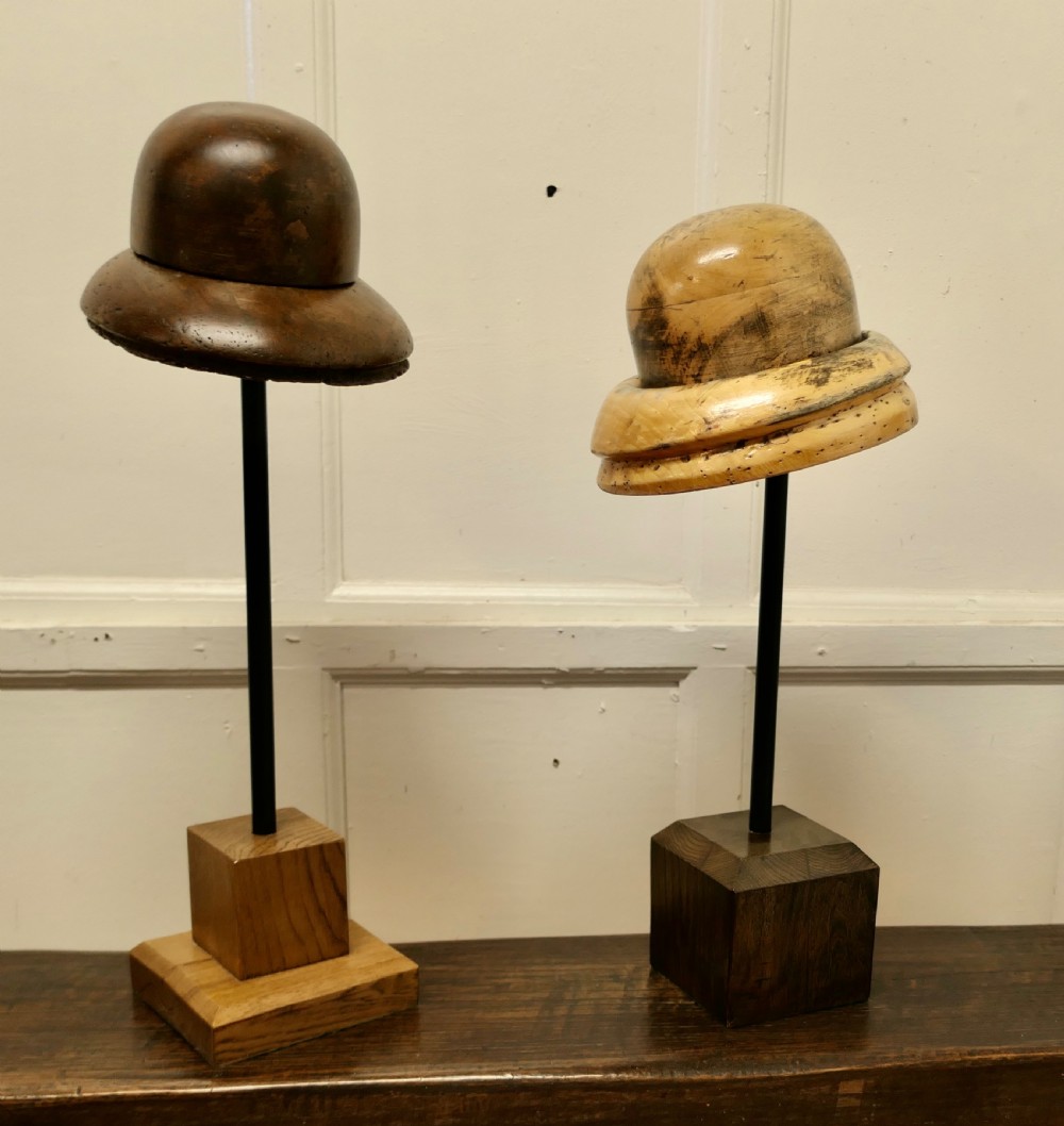 An antique French fruitwood hat display stand featuring a carved wooden crown form mounted on a black metal shaft with a wooden base. View V