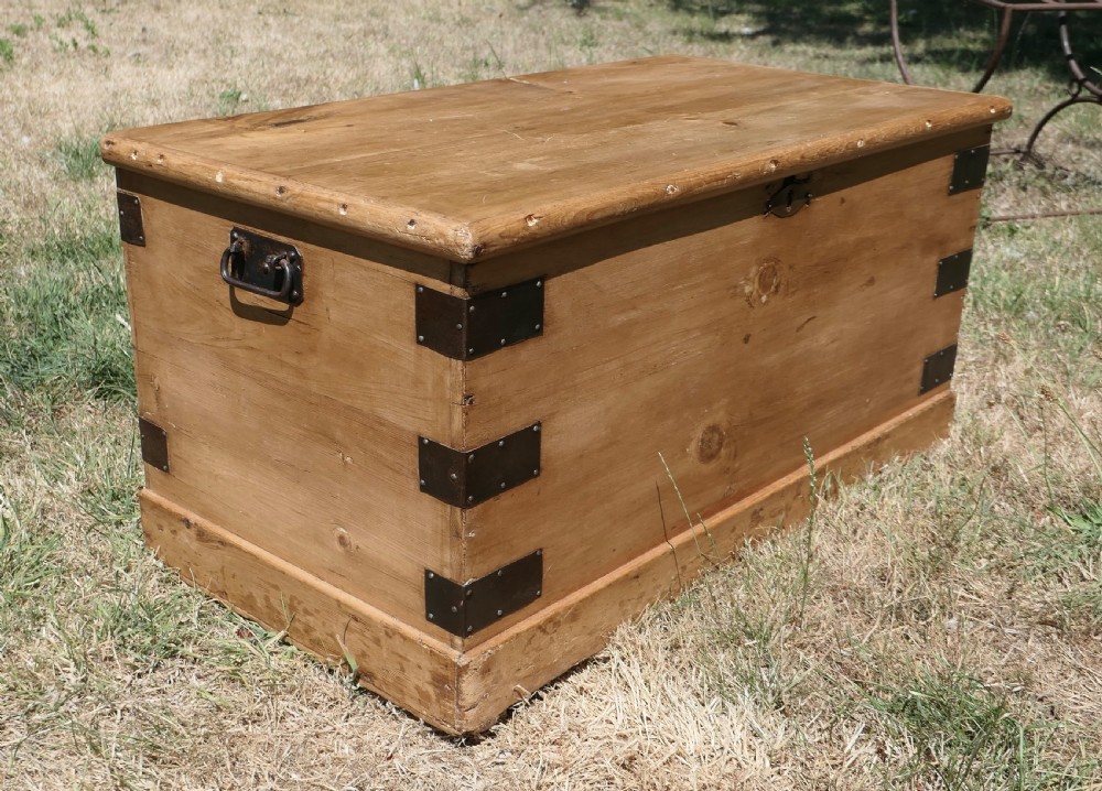 A rectangular stripped pine blanket box with dark iron corner brackets, a keyhole escutcheon, and a flat hinged lid. View V