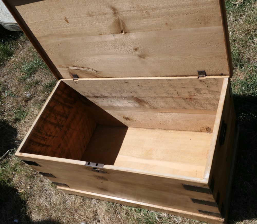 A rectangular stripped pine blanket box with dark iron corner brackets, a keyhole escutcheon, and a flat hinged lid. View VI