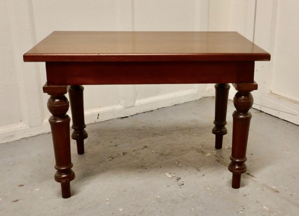 A rectangular Victorian mahogany occasional table with turned legs and a warm brown polish.