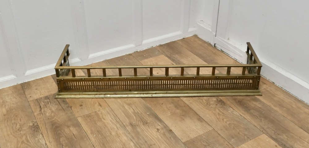 A Victorian solid brass fireplace fender featuring a slotted lower gallery, stud detailing, and an elevated top rail. View II