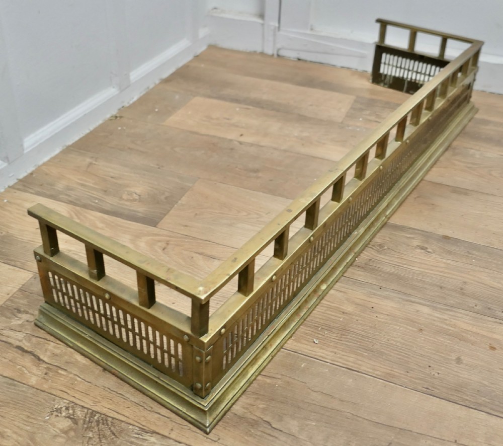 A Victorian solid brass fireplace fender featuring a slotted lower gallery, stud detailing, and an elevated top rail. View IV
