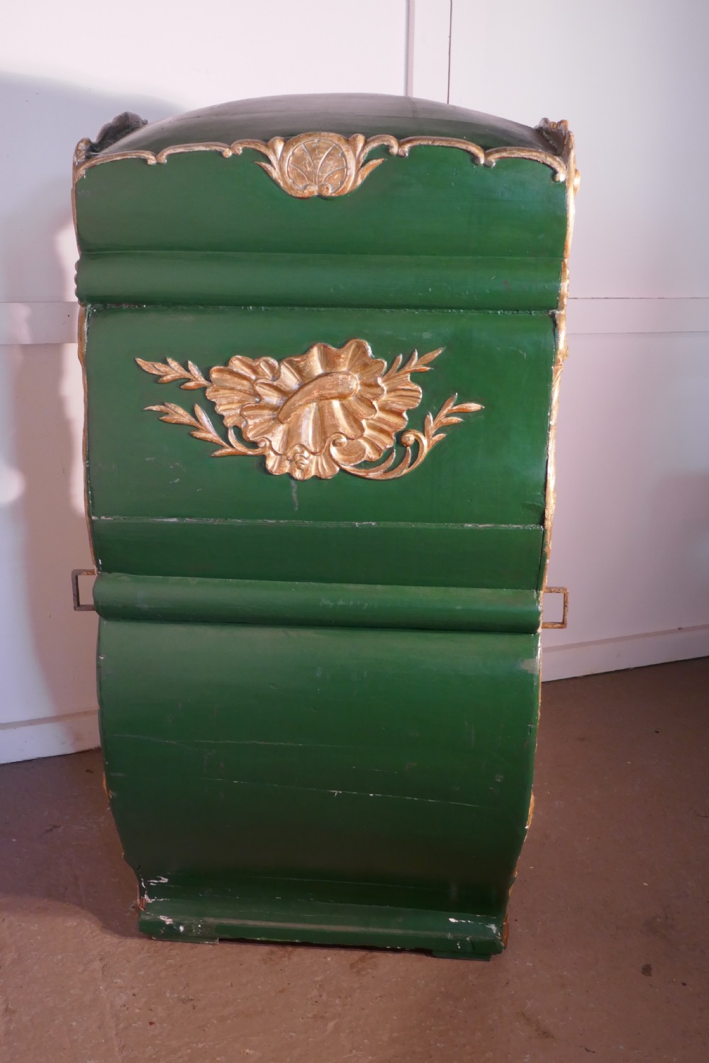 A 19th-century green painted and giltwood Italian sedan chair featuring hand-carved scrollwork, window openings, gold fabric lining, and wooden carrying poles. View X
