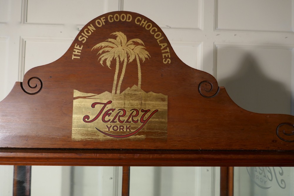 An antique mahogany glazed shop display cabinet with a pediment cresting featuring Terrys of York branding and etched glass panels. View III