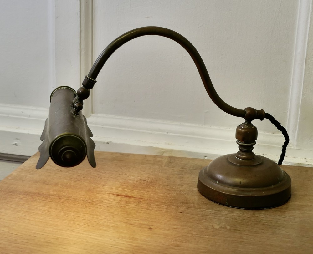 An antique brass desk lamp featuring a curved gooseneck stem, a circular weighted base, and an adjustable scalloped shade. View III