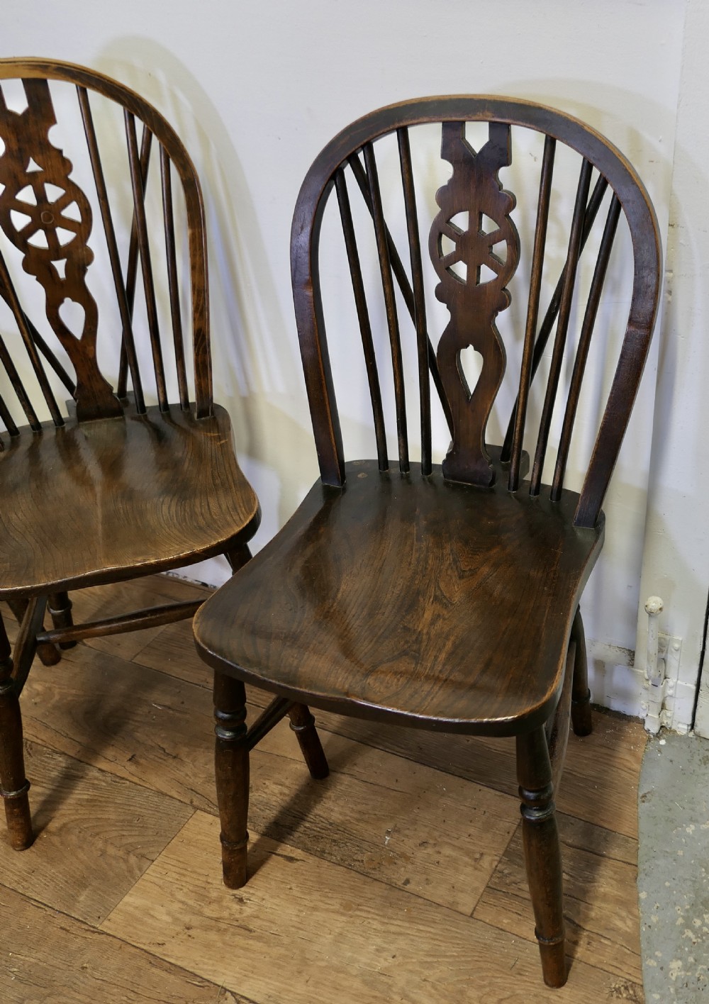 A set of five dark brown Victorian Windsor dining chairs with pierced wheelback central splats, hoop backs, and turned legs. View III