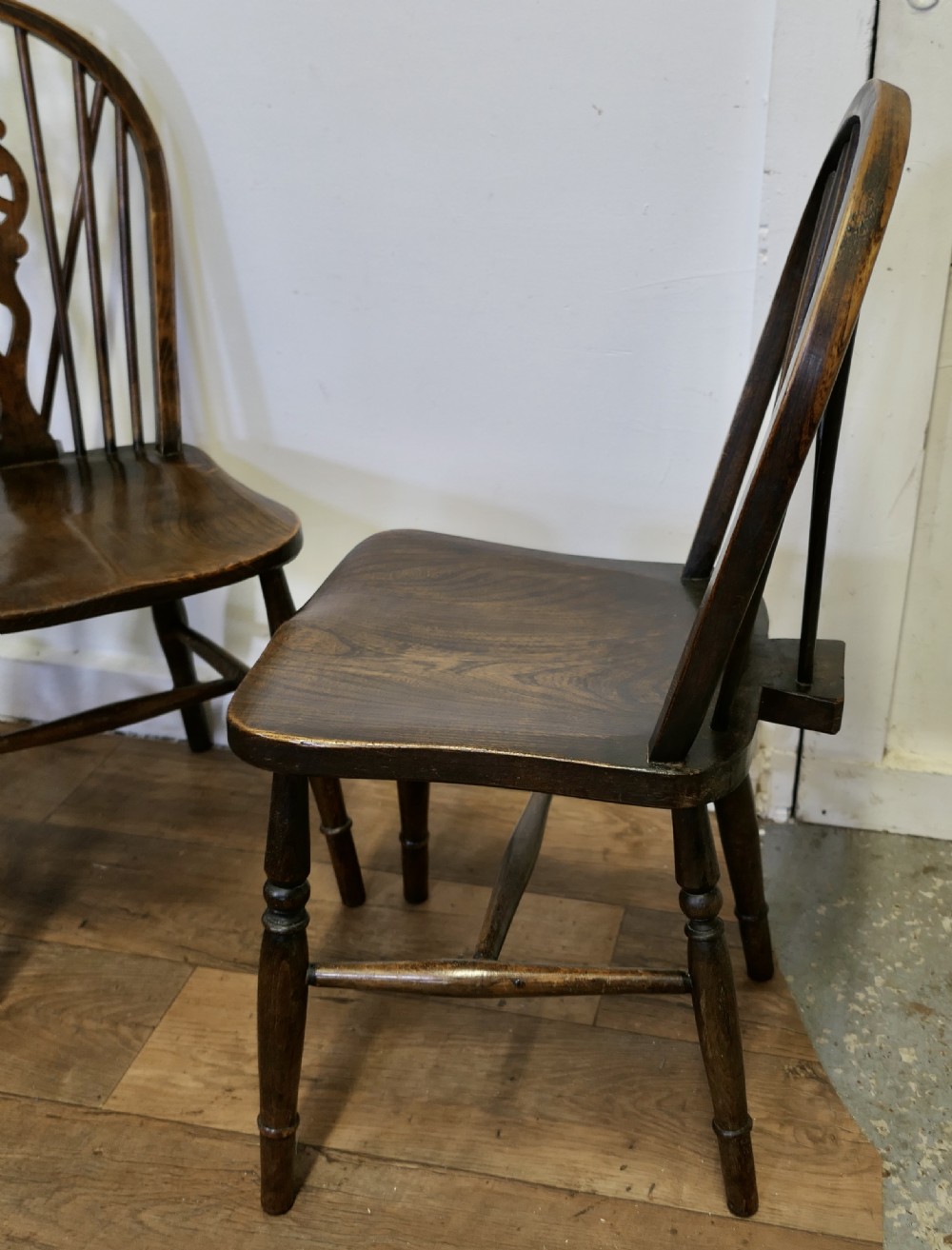 A set of five dark brown Victorian Windsor dining chairs with pierced wheelback central splats, hoop backs, and turned legs. View IV
