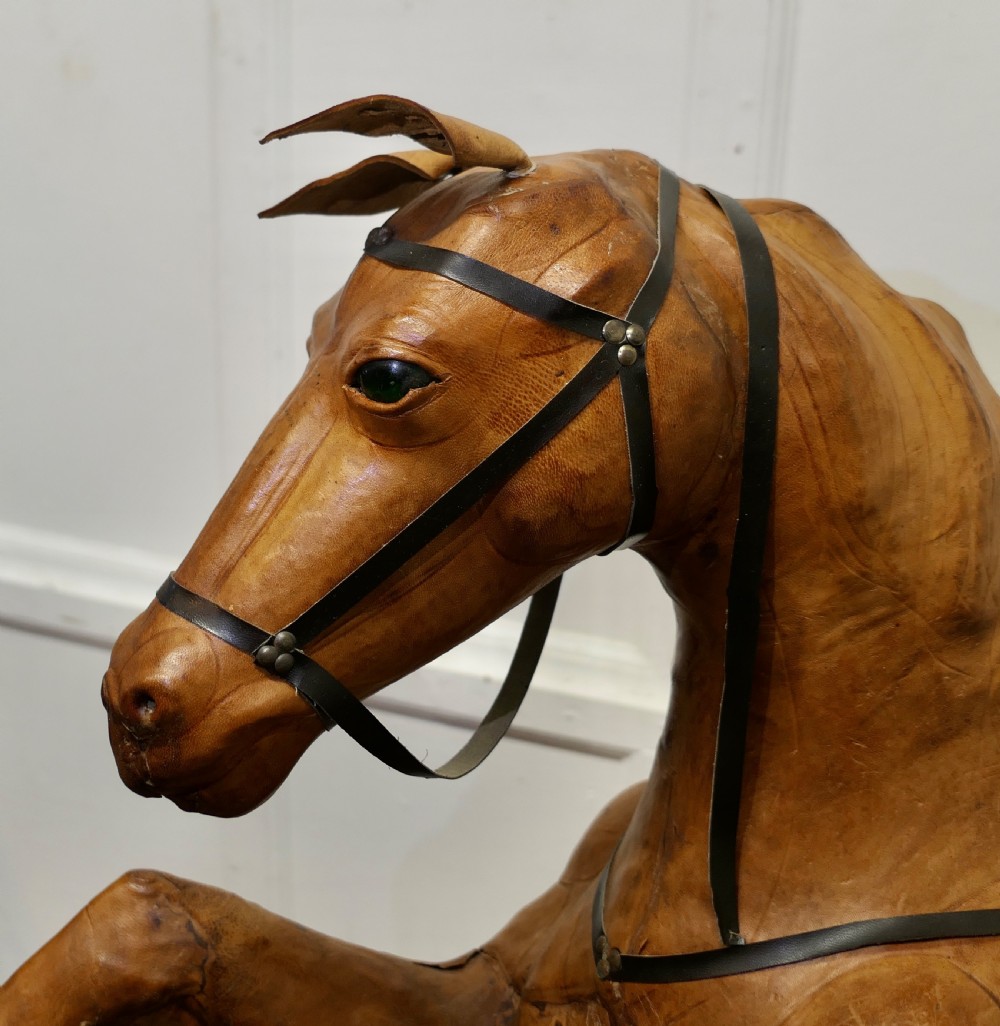 A life-size Arts and Crafts leather model of a rearing horse with dark leather bridle and saddle, mounted on a rustic wooden base. View V