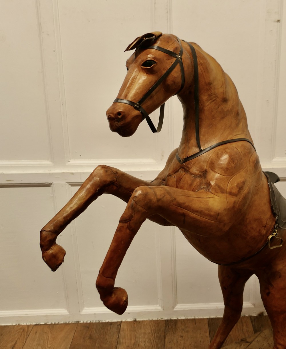 A life-size Arts and Crafts leather model of a rearing horse with dark leather bridle and saddle, mounted on a rustic wooden base. View VI