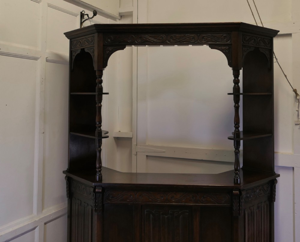 A dark brown carved oak canopy bar featuring turned spindle columns, open side shelves, an overhead frieze, and vertical panelled detailing on the base. View III