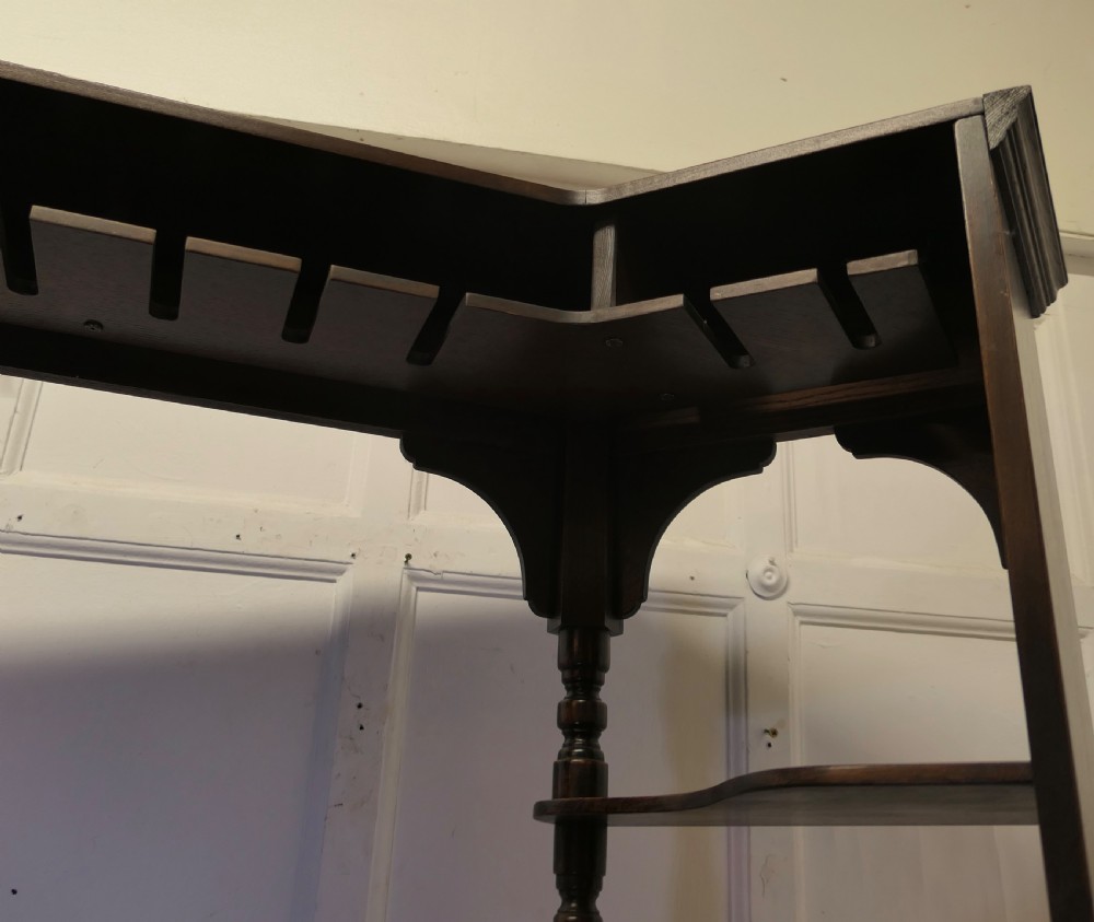 A dark brown carved oak canopy bar featuring turned spindle columns, open side shelves, an overhead frieze, and vertical panelled detailing on the base. View IX