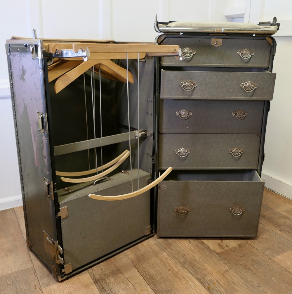 An open Art Deco Hartmann fitted steamer trunk featuring a section with wooden clothes hangers and a section with five pull-out drawers. View X